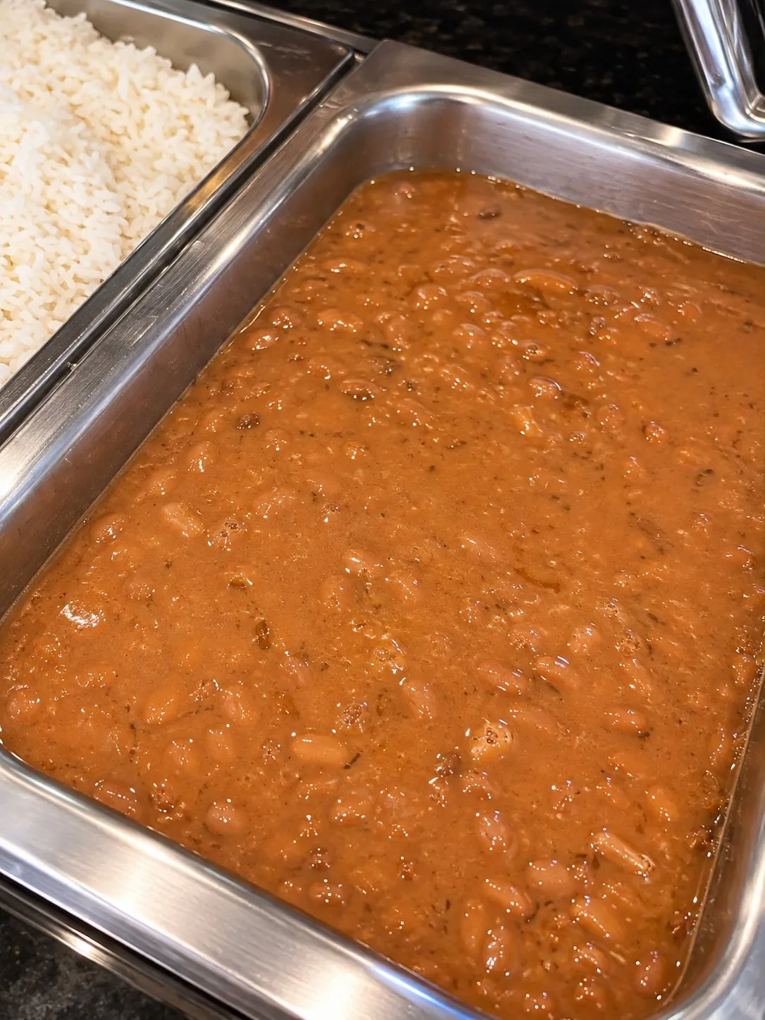 Feijão caseiro ao lado do arroz no buffet da Casa da Sogra